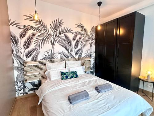 - une chambre avec un grand lit et du papier peint tropical dans l'établissement Urban Oasis Paris, à Paris