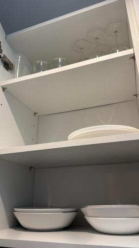 a kitchen with white plates and bowls on shelves at DaxLodge T3 cosy in Dax