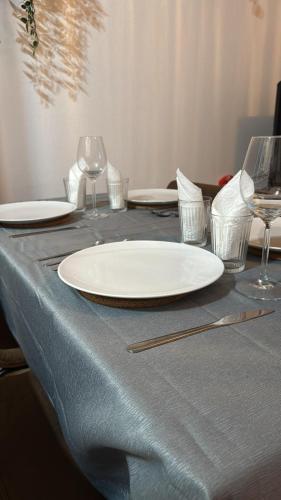 a table with two white plates and wine glasses at DaxLodge T3 cosy in Dax