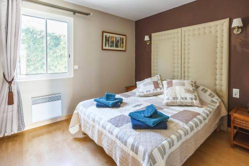 - une chambre avec un lit et des serviettes bleues dans l'établissement Villa Les Arches by Villa Plus, à Villedaigne