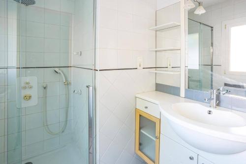 une salle de bain blanche avec un lavabo et une douche dans l'établissement Villa Les Arches by Villa Plus, à Villedaigne