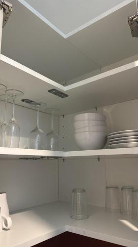 a kitchen with glasses and plates on a shelf at DaxLodge T3 cosy in Dax