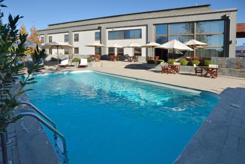 a large blue swimming pool in front of a building at Inca Hoteles in Los Andes