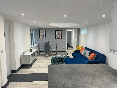 a living room with a blue couch and a table at The Lucia Apartments II - 1 Bedroom Town Centre Apartment - Contractor Friendly - Free Parking - Full Kitchen - Washer Dryer - Spacious - Ideal for Work Stays in Huntingdon