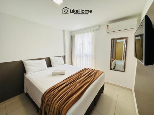 a bedroom with a large bed with a television on the wall at Eco Summer Tambaú, LikeHome in Tambaú