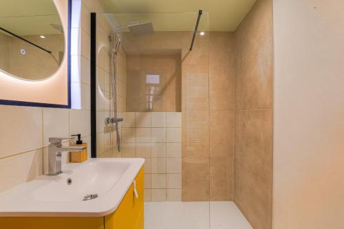 une salle de bain avec un lavabo et une douche dans l'établissement Expérience Bahiana avec balnéo, à Lyon
