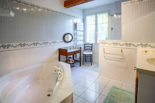 La salle de bains blanche est pourvue d'une baignoire et d'une table. dans l'établissement Villa Sur Lile by Villa Plus, à Roquemaure