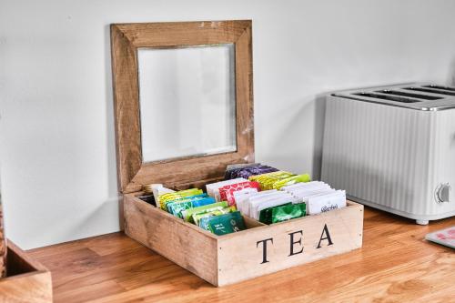 a box of tea on the floor next to a mirror at Carnbore House BnB in Bushmills