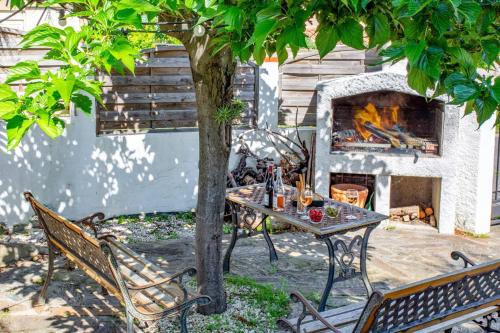 a table and chairs in front of a fireplace at Villa du Soleil by Villa Plus in Laroque-des-Albères