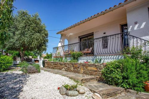 a house with a stone wall and a balcony at Villa du Soleil by Villa Plus in Laroque-des-Albères