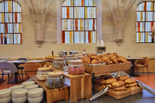a table filled with lots of different types of bread at Appart'hôtel Odalys City - Dijon Centre Les Cordeliers in Dijon