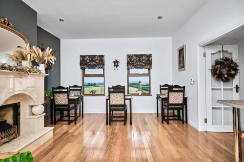a living room with a fireplace and a table and chairs at Carnbore House BnB in Bushmills