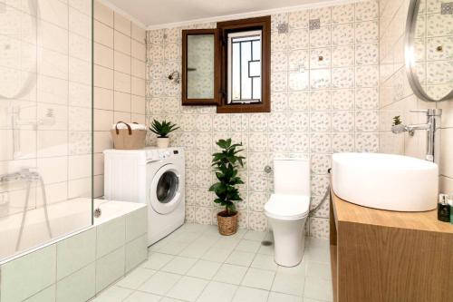 a bathroom with a washing machine and a sink at Villa Observer by Villa Plus in Kipseli