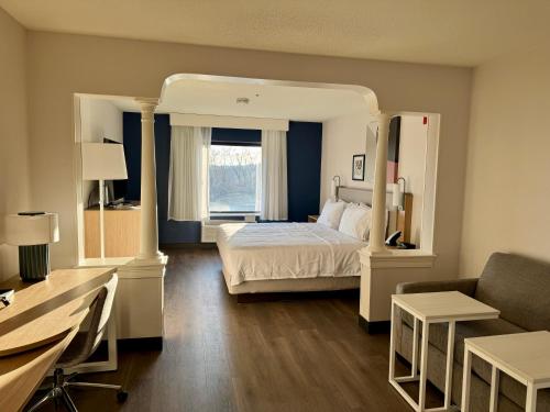 a hotel room with a bed and a couch at Spark by Hilton Woburn Boston in Woburn