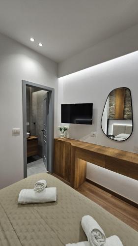 a bedroom with a bed with a mirror and a tv at Elisavet's Room in Gjirokastër