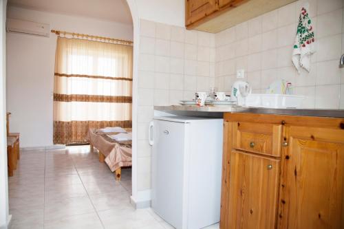 een keuken met een witte koelkast en een wastafel bij Archodia Studios in Kefalos