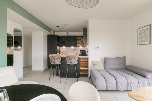 un salon avec un canapé et une cuisine dans l'établissement Cosy et Design proche Groupama Stadium, à Villeurbanne