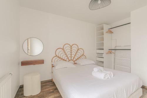- une chambre blanche avec 2 lits et un miroir dans l'établissement Cosy et Design proche Groupama Stadium, à Villeurbanne