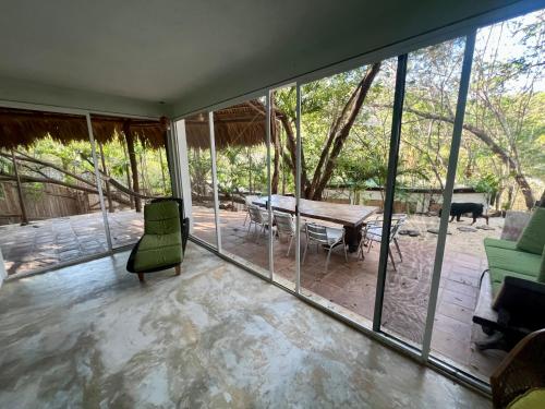 a room with glass windows and a table and chairs at Casa Pauline Beach house habitaciones con acceso directo a playa y alberca in Arroyo Cruz