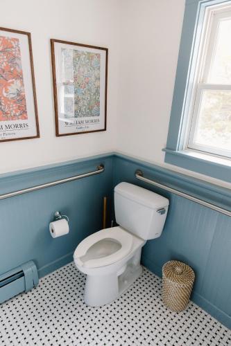 a bathroom with a white toilet in a blue wall at The Ipswich Inn in Ipswich