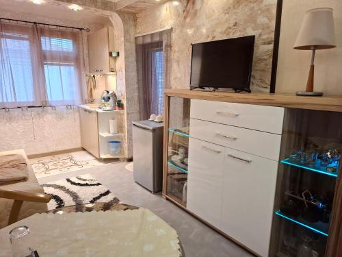a kitchen with a tv on top of a dresser at Magi Sunrise in Balchik