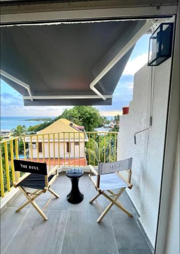 a balcony with two chairs and a view of a building at Sublime studio vue sur mer in Îlet à Christophe