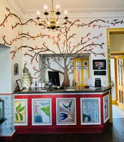 an art gallery with a tree on the wall at The Sheldon B&B - FREE private parking in Eastbourne