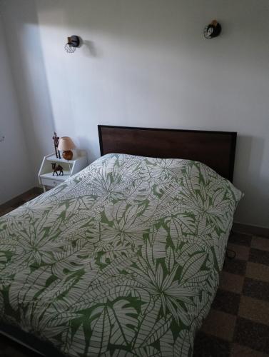 - une chambre dotée d'un lit avec un couvre-lit vert et blanc dans l'établissement Country house, à Le Buisson Genois