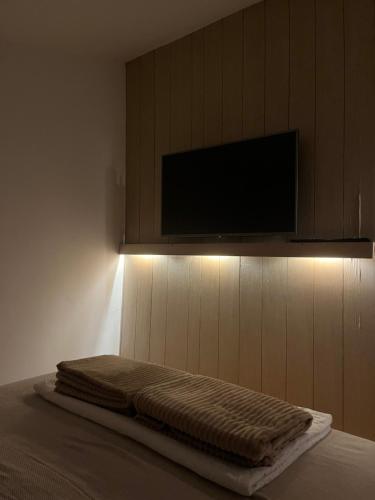 Un dormitorio con una cama con un televisor de pantalla plana. en Tara Lapčići Budva, en Budva