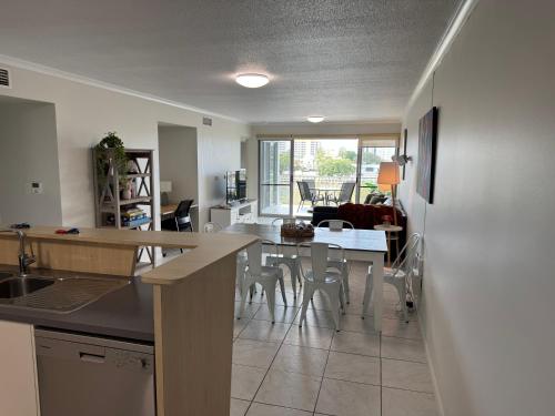 a kitchen and living room with a table and chairs at City Stadium Apartment on the Riverfront 38 in Townsville