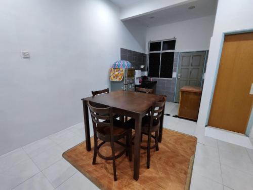 a kitchen with a table and chairs in a room at Homestay Temerloh Free Netflix Wi-fi 300MBPS 4 Bedroom 3 Air-cond Water Heater Water Filter in Temerloh