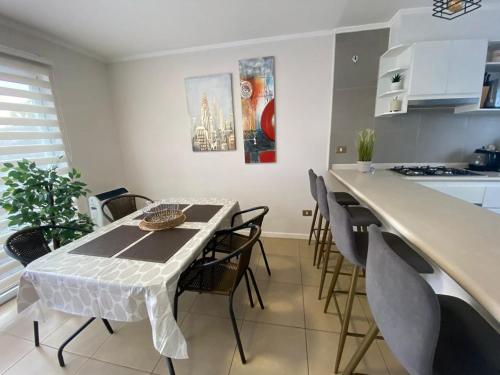 a kitchen with a table and chairs in a room at Hermosa casa amoblada dos dormitorios mas dos baños in Los Ángeles
