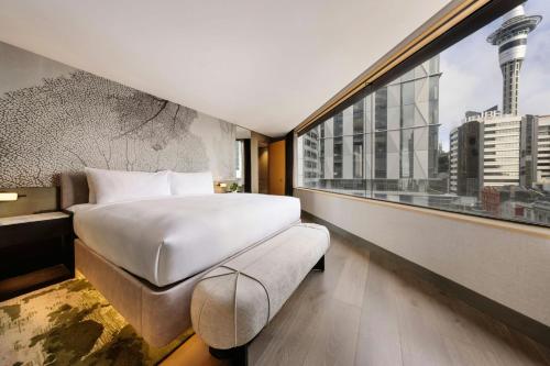 a hotel room with a bed and a large window at JW Marriott Auckland in Auckland