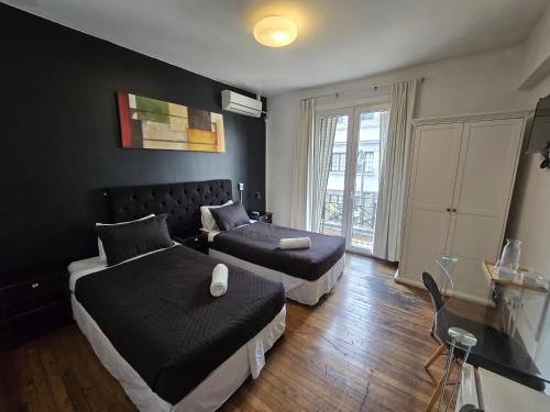 a hotel room with two beds and a couch at Tremo Patio Bellavista in Santiago