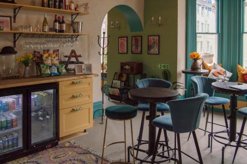 a bar with stools and tables in a room at The Sheldon B&B - FREE private parking in Eastbourne