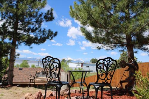 two chairs and a table in a yard with trees at Colorado Cottage W/Mountain View in Colorado Springs