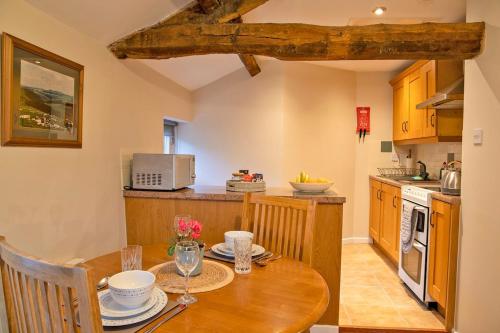 Il comprend une cuisine avec une table en bois et un comptoir. dans l'établissement Dove Cottage, à Hartington