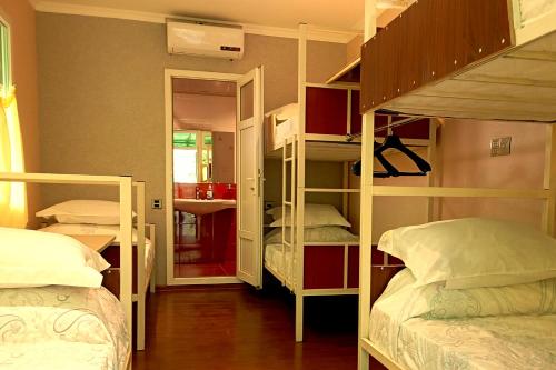 a room with two bunk beds and a mirror at Grandsons Hostel in Mekhrably
