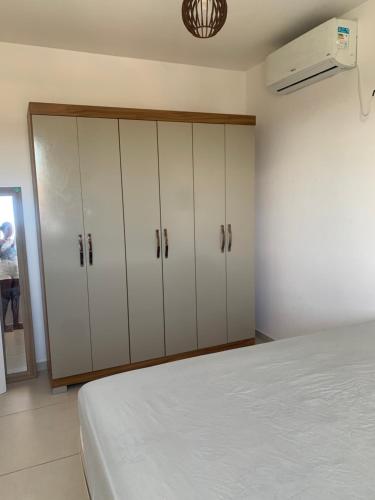 a bedroom with white cabinets and a bed at Cantinho da day in Aracaju