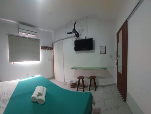 a bedroom with a bed and a flat screen tv at Pousada Cantinho de Minas Da Tânia in Cabo Frio