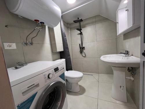 Un baño con lavadora y lavabo. en Apartamente me qera Golem, en Golem