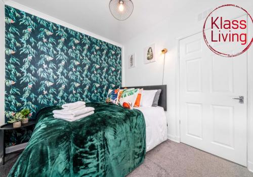 a bedroom with a bed and a green wall at Uddingston Apartment by Klass Living in Uddingston