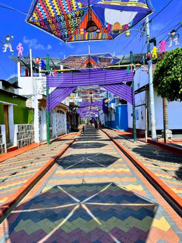 a walkway with a purple bridge and an umbrella at Hotel Mercy in San Juan La Laguna