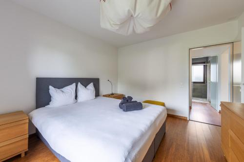 a bedroom with a large white bed and a television at Feel like home, close to Verzasca, Tenero, Locarno in Gordola