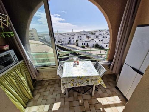 un balcon avec une table et une vue sur une ville dans l'établissement Résidence Belle Plage - APPT T2 MEZZANINE 4 couchages PORT LEUCATE. Réf: 3BP_66A MAE-1853, à Leucate