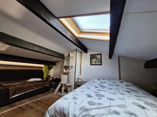 - une chambre avec un grand lit et une lucarne dans l'établissement Résidence Belle Plage - APPT T2 MEZZANINE 4 couchages PORT LEUCATE. Réf: 3BP_66A MAE-1853, à Leucate