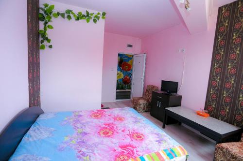 1 dormitorio con cama con estampado de flores en Hostel Shatrata, en Bogomilovo