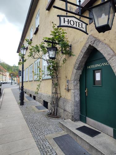 a building with a green door on a street at Altwernigeröder Apparthotel in Wernigerode