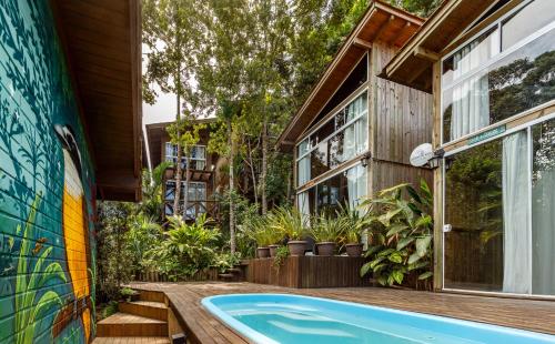 a house with a swimming pool next to a building at Moradas do Vale Praia do Rosa in Praia do Rosa