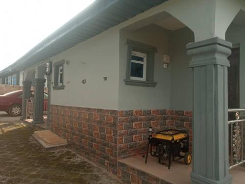 a building with a brick pillar with a motorcycle on it at 2-Bedroom Tradebybata Apartments around FUNAAB Abeokuta in Abeokuta